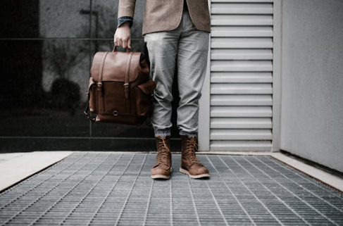 Man posing with brown leather shoes and a brown leather bag from Cycas d'Or