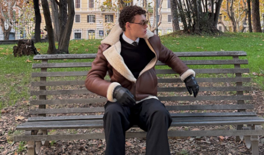 Model sitting in a park and wearing a Cycas d'Or Shearling Coat